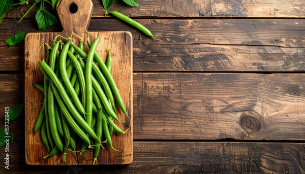Obraz Fresh green beans on rustic wooden cutting board with leaves