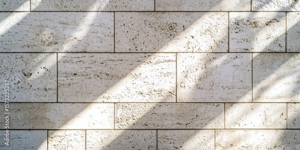 Fototapeta Detailed white stone facade under soft sun rays, casting gentle shadows