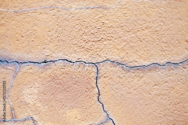 Fototapeta Deep cracks on plaster wall background texture damaged old surface pattern detail
