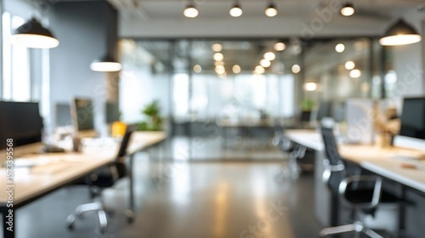 Fototapeta Modern office workspace with blurred background showcasing desks, chairs, and lighting fixtures in a collaborative environment.