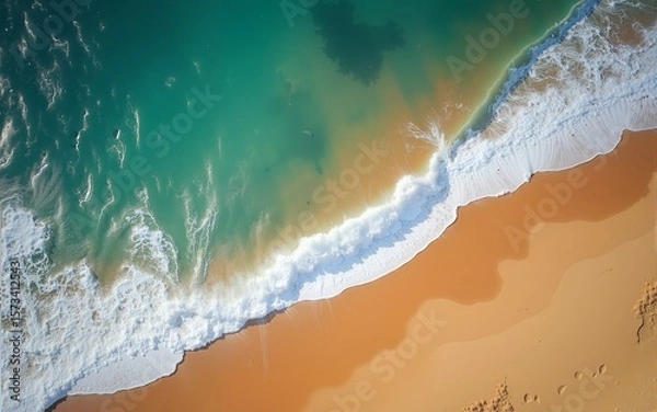 Obraz Top-down view of ocean waves crashing against the golden sandy shore, capturing the natural beauty and contrast of the beach and sea. Landscapes. High quality