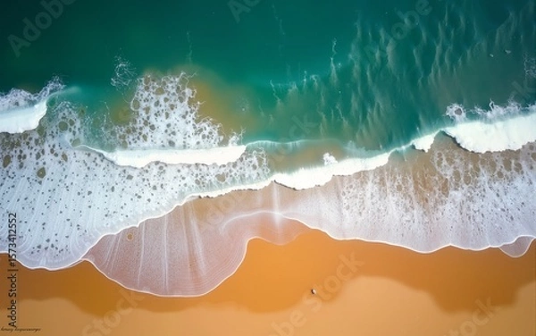 Obraz Top-down view of ocean waves crashing against the golden sandy shore, capturing the natural beauty and contrast of the beach and sea. Landscapes. High quality