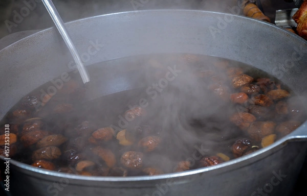 Fototapeta Large metal pot brimming with dried fruit compote, with steam rising from the hot concoction