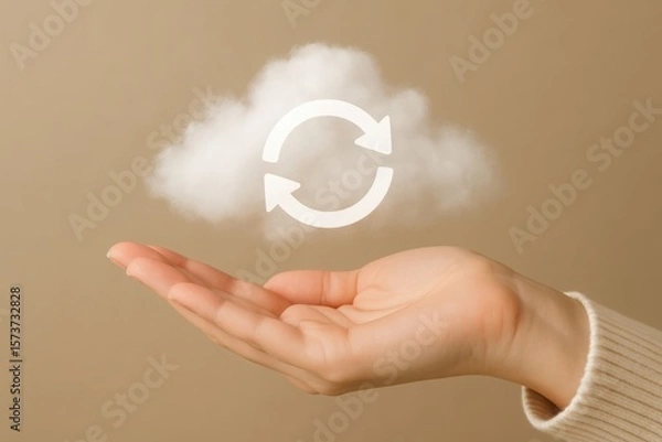 Fototapeta A hand gently holds a fluffy white cloud with a circular refresh symbol, representing data and cloud computing