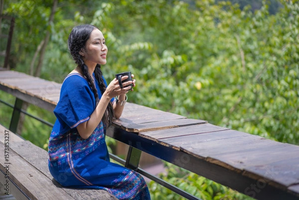 Fototapeta Beautiful Asian Woman Enjoying Morning Coffee on Mountain Balcony in Chiang Mai, Thailand.