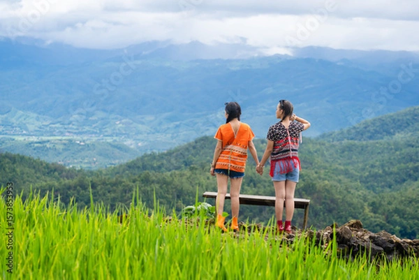 Fototapeta Group of pretty teenage travellers wearing custom-made Karen dresses in a natural green terraced rice fields at Pa Bong Piang rice fields, Mae Chaem, Doi Inthanon, Chiang Mai, Thailand.