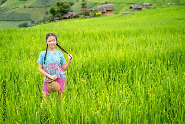 Fototapeta Pretty teenage travellers wearing custom-made Karen dresses in a natural green terraced rice fields at Pa Bong Piang rice fields, Mae Chaem, Doi Inthanon, Chiang Mai, Thailand.