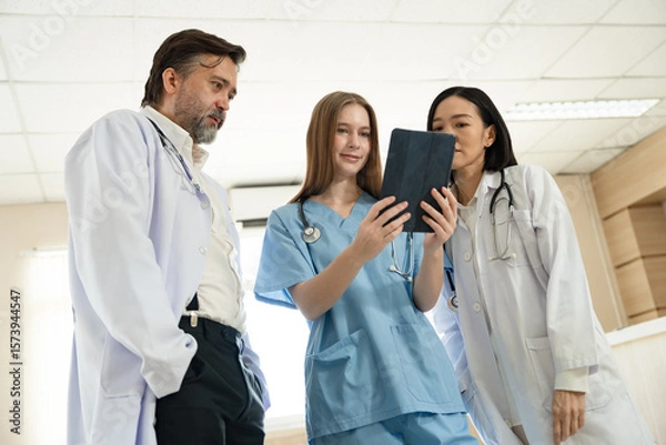 Obraz Caucasian woman doctor use tablet computer with team working at hospital	