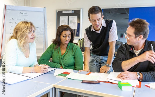 Fototapeta Adult Education: Small Group Learning. A group of mature students working together with their teacher. From a series of related images.