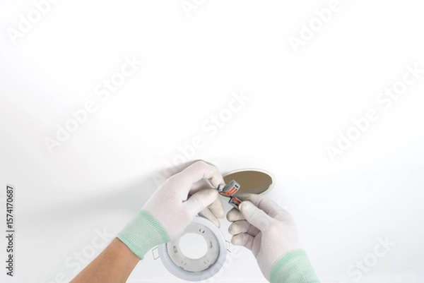 Fototapeta close-up of gloved hands connecting lighting wiring, suspended ceiling, clamps