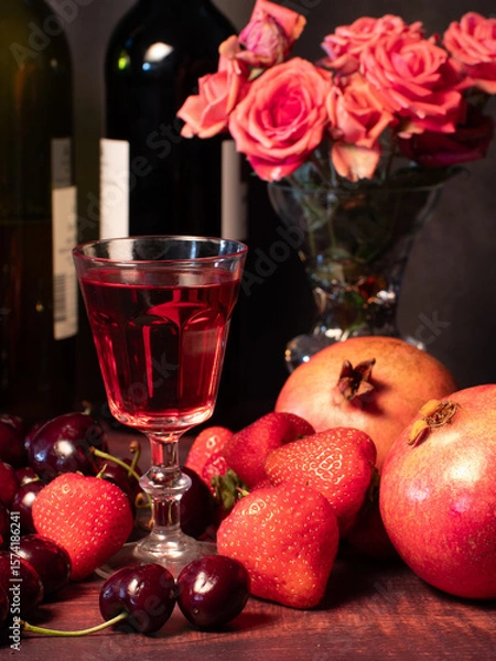 Obraz Still life with rose flowers, summer fruits, bottles of wine and a glass of wine. Pomegranate, cherry, sweet cherry, strawberry and watermelon. Alcohol. The still life is stylized as an old painting.