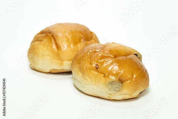 Obraz Bread roll with raisins on a white background.