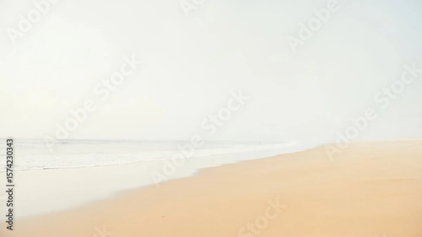 Fototapeta Coastal landscape with a sandy beach and ocean waves under a bright overcast sky creating a minimalist aesthetic