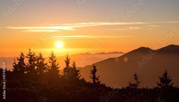 Fototapeta sunset over layered mountain forest with silhouetted trees and glowing sky creating tranquil depth and natural majesty