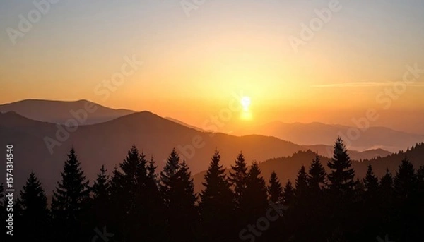 Fototapeta sunset over layered mountain forest with silhouetted trees and glowing sky creating tranquil depth and natural majesty
