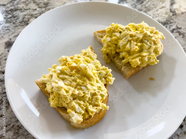 Obraz Open-faced egg salad sandwich on white plate