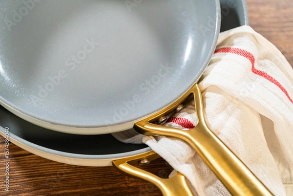 Obraz Overlapping Ceramic Pans with Red-Striped Towel