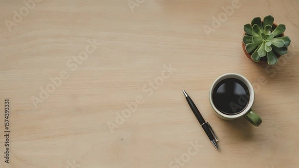 Obraz A tranquil workspace with a steaming coffee cup, succulent plant, and sleek pen arranged on a light wooden desk, promoting a serene and focused atmosphere