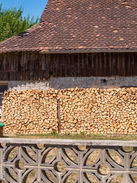 Fototapeta Rustic Wooden Building with Stacked Woodpile