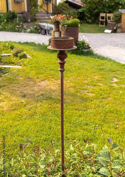 Fototapeta Rustic Garden Torch Stand in Lush Greenery