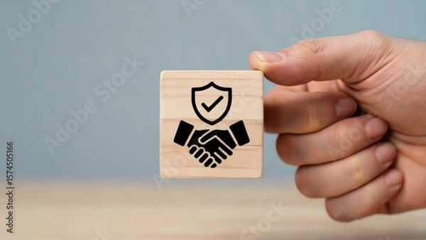 Obraz Secure handshake represented on a wooden block held by a hand