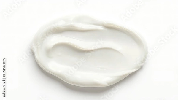 Fototapeta A single dollop of smooth, white lotion or cream is placed against a bright and clean white backdrop