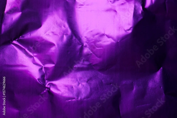Fototapeta Crumpled purple foil creating unique textures and patterns under soft light in a compact space