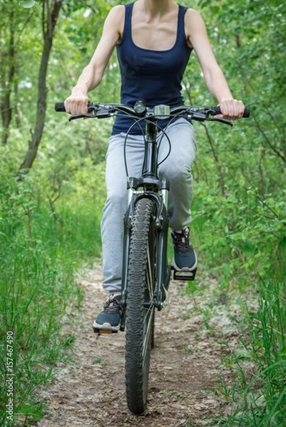Fototapeta A trip on a mountain bike along the forest path. Sports and the concept of active life in the summer. Vertical frame