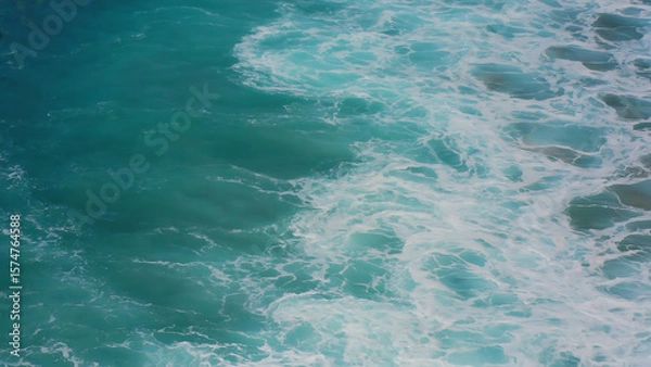 Fototapeta Turquoise Ocean Waves Crashing with Foamy Whitecaps, creating a dynamic and mesmerizing seascape.
