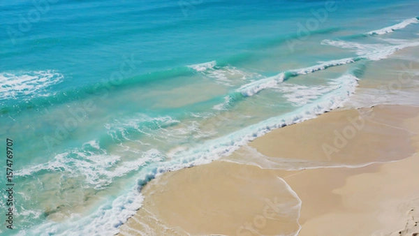 Fototapeta Aerial view of a beautiful beach with turquoise water and golden sand, creating a serene and inviting scene.