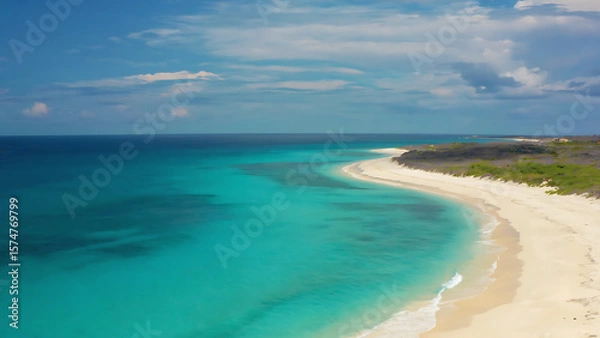 Fototapeta Turquoise waters meet white sand beach under a partly cloudy sky, creating a serene tropical paradise.
