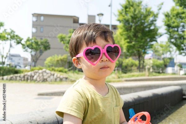 Obraz ハートのサングラスをかけた男の子がスイーツを楽しむ夏の屋外ポートレート｜家族レジャー・お祭りイメージに最適な子ども写真