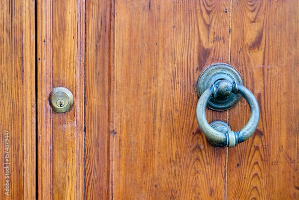 Fototapeta Antique wooden door featuring a metallic knocker and keyhole, highlighting themes of security, history, and traditional craftsmanship