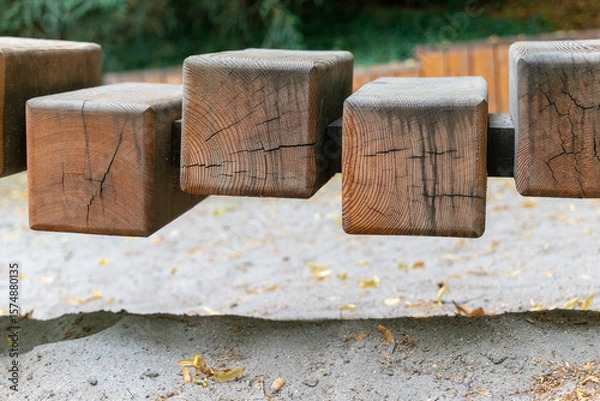 Fototapeta Unique wooden blocks create an intriguing play structure in an outdoor garden setting with soft sand underfoot