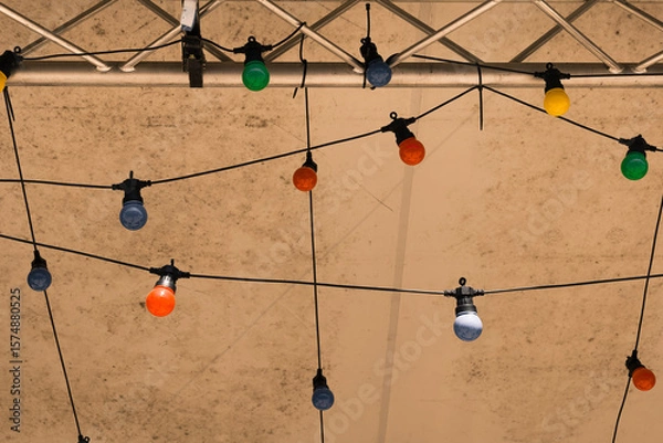 Fototapeta Colorful decorative lights create a festive atmosphere under a tent during an evening gathering in a warm summer setting