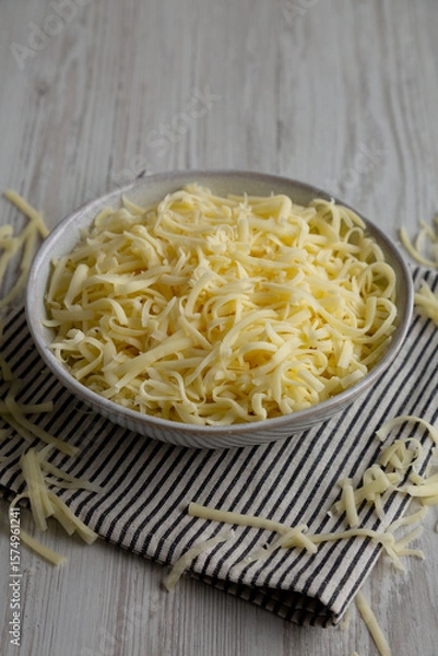 Fototapeta Organic Shredded Mozzarella Cheese in a Bowl, side view.