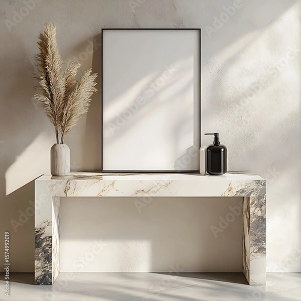 Fototapeta Neutral interior showcases a blank canvas frame complemented by elegant pampas grass and marble console table, bathed in soft sunlight.