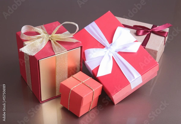 Obraz red and gold gift box on wood background.