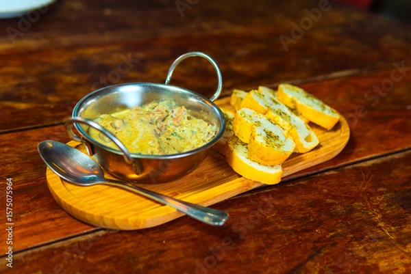 Fototapeta Creamy dip with toasted garlic bread is a perfect appetizer served on a wooden tray.