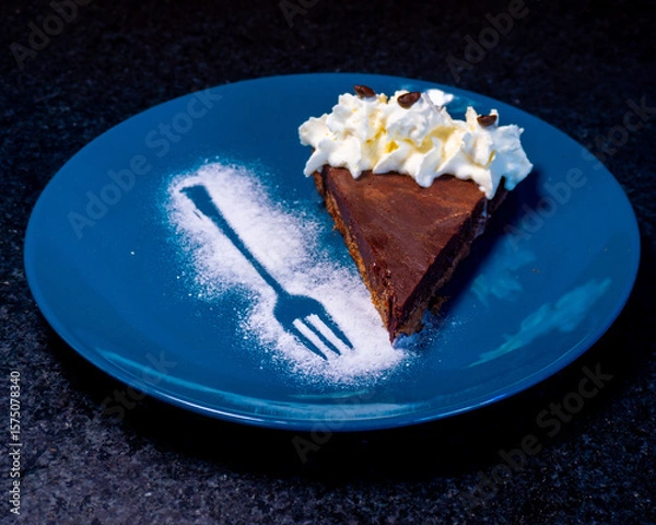 Fototapeta A delicious slice of chocolate cake with whipped cream and a unique design.