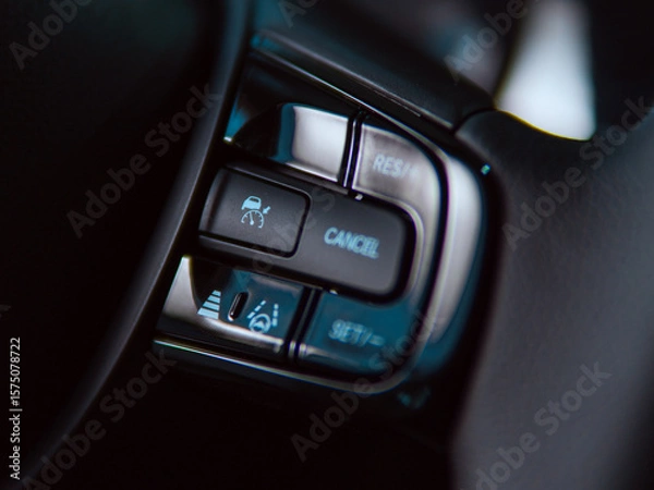 Fototapeta Car steering wheel controls with cruise control and lane assist features in a modern vehicle.