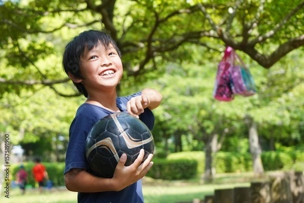 Obraz サッカーボールと笑顔の小学生の子供