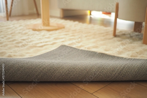 Fototapeta Soft gray rug partially rolled up in a cozy living room