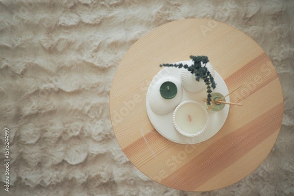 Fototapeta Decorative candles and plants arranged on a wooden table