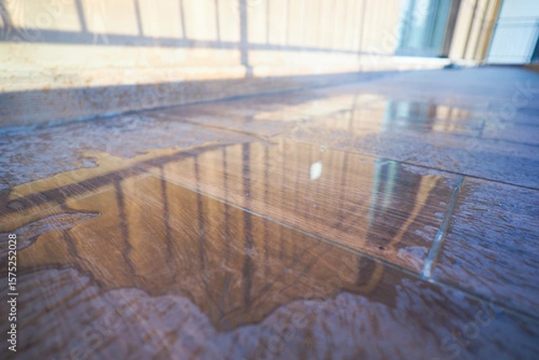 Fototapeta Reflection of sunlight on a wet floor in a modern building
