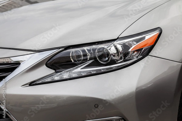 Obraz The headlight of a silver car is lit up