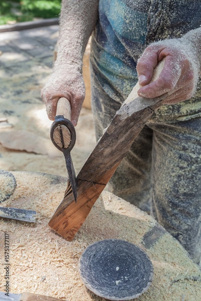 Obraz Man is cutting wood with a saw