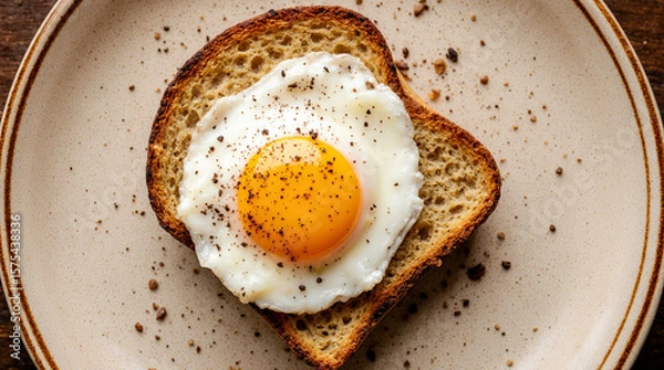 Fototapeta Delicious fried eggs on toast, seasoned with pepper, served on plates in a rustic, home-style presentation. AI generated.
