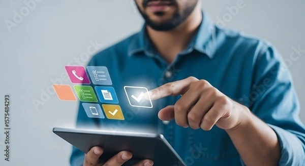 Fototapeta Digital Canvas A modern man in a blue shirt interacts with glowing app icons on a sleek tablet set against a soft grey
