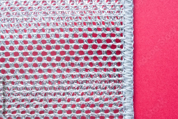 Obraz Macro shot highlights the abstract texture of a cleaning sponge, with a striking contrast between metallic and red hues. Photo. High resolution.
